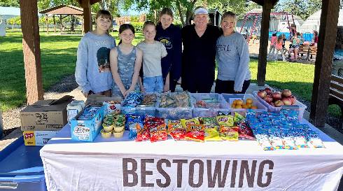 Volunteers and kids at the free summer lunch table under the park pavilion in Athol